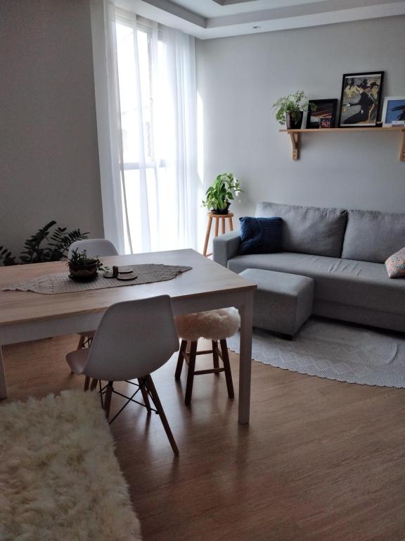 uma sala de estar com uma mesa e um sofá em HO1016 em Porto Alegre