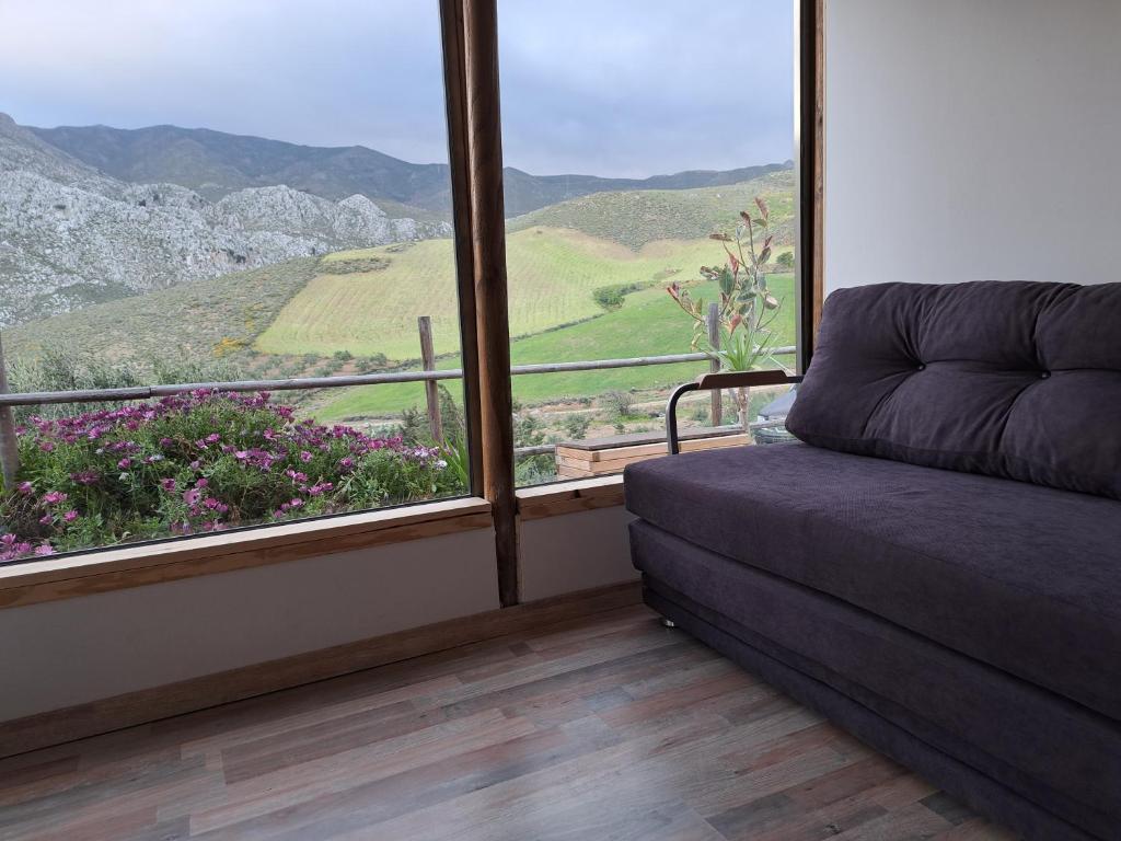 a room with a couch and a window with a view at Wooden House at the Mountain-private in Paránimfoi