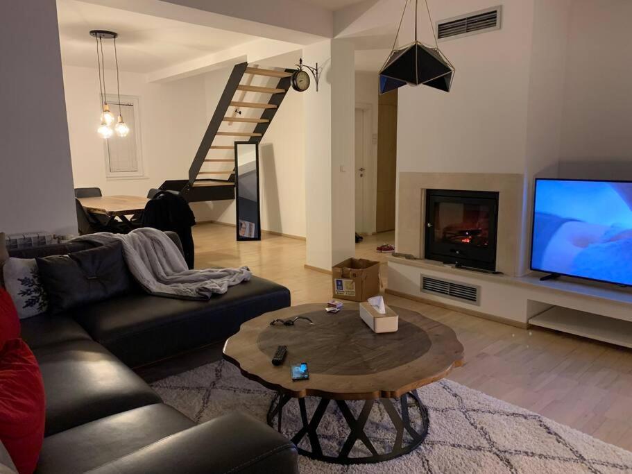 a living room with a couch and a tv and a table at Modern apartment in Skopje in Skopje