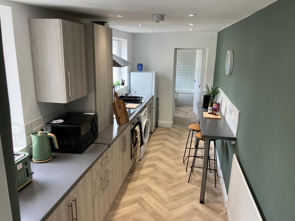 a kitchen with a counter and a stove top oven at Sunderland Stays, Rose, City Centre, HS Wi-Fi, Smart TV & Free Parking in Sunderland
