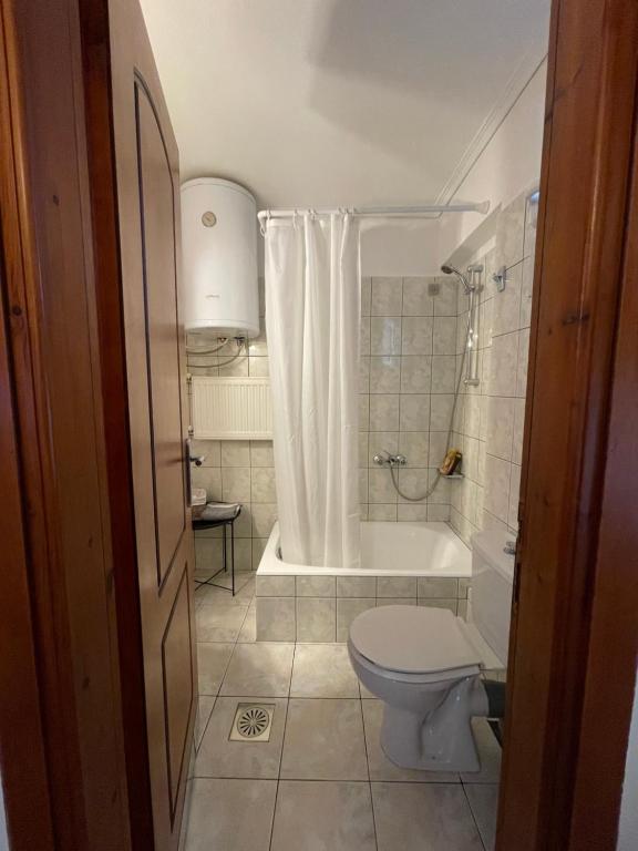 a bathroom with a toilet and a tub and a sink at Flo&#39;s Apartments in Missolonghi