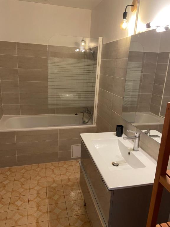 une salle de bain avec un lavabo blanc et une baignoire dans l'établissement Maison a 5 min des plages, à Six-Fours-les-Plages