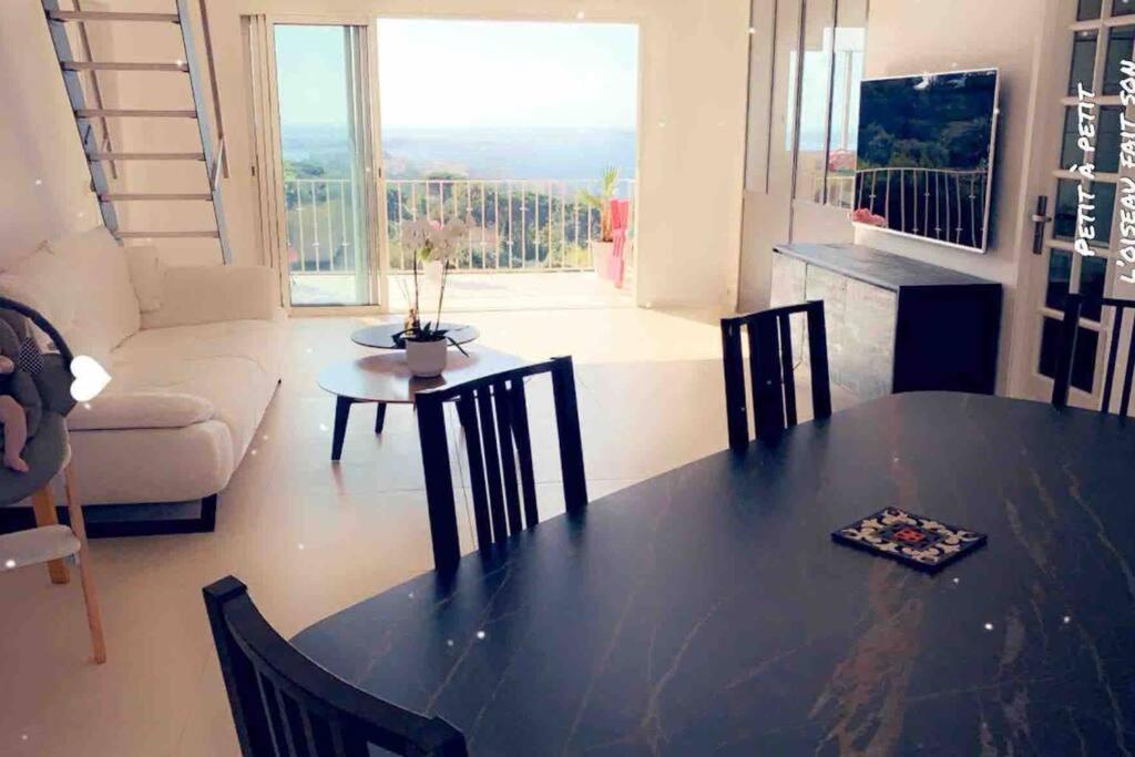 sala de estar con mesa, sillas y sofá en Appartement CANNES, vue mer triples exposition en Cannes