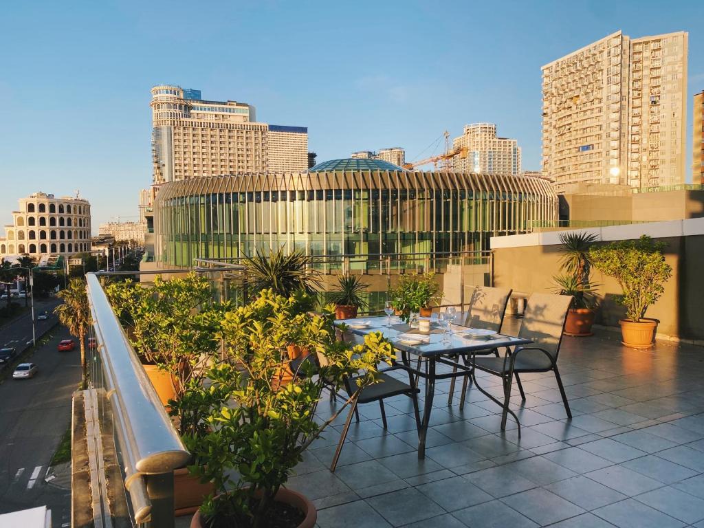 - Balcón con mesa y sillas y vistas a la ciudad en Sunset Apartment, en Batumi