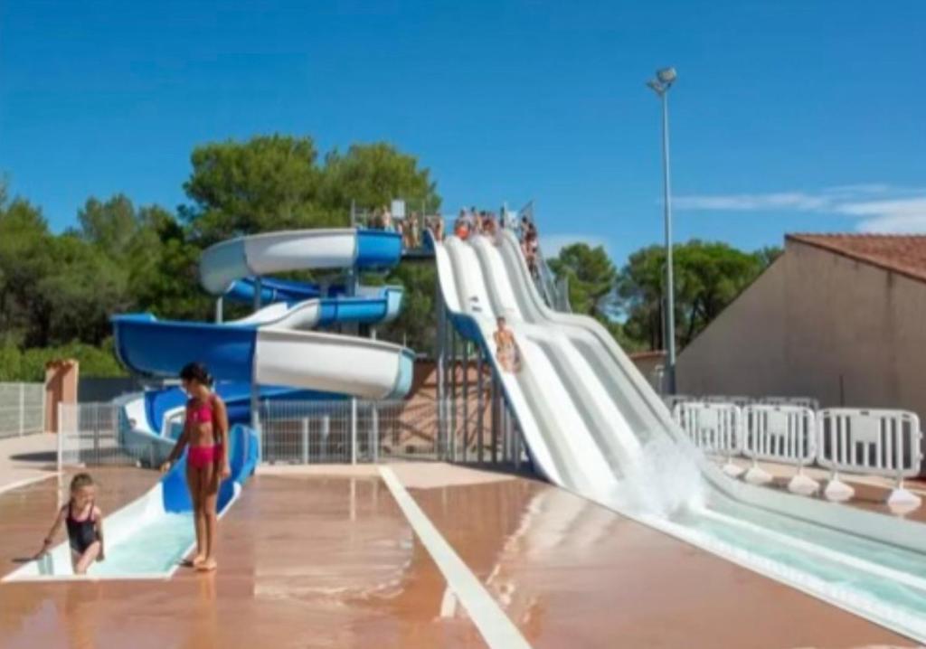 a family playing on a water slide at a water park at Camping Oasis village in Puget-sur-Argens