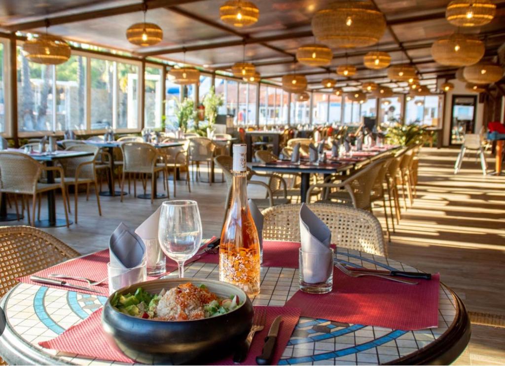 a table with a bowl of food and a bottle of wine at Camping Oasis village in Puget-sur-Argens