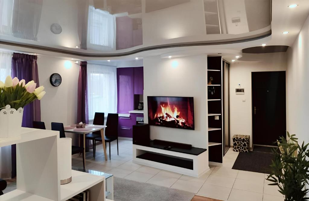 a living room with a tv and a table at Coastal Comfort Apartments in Liepāja