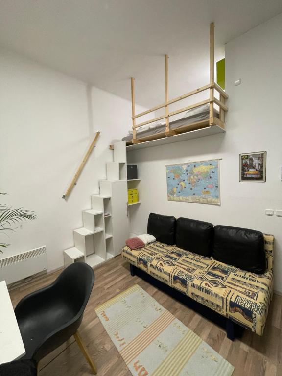 a living room with a couch and a staircase at Brasilia apartment in Ljubljana