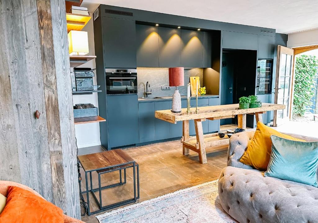 a living room with a couch and a kitchen at Luxe vakantiewoning, Maison Masko, tussen Brugge en Oostende in Jabbeke