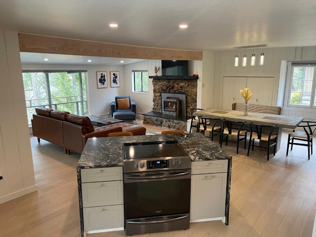 a kitchen and living room with a stove and a table at The River House in Grants Pass