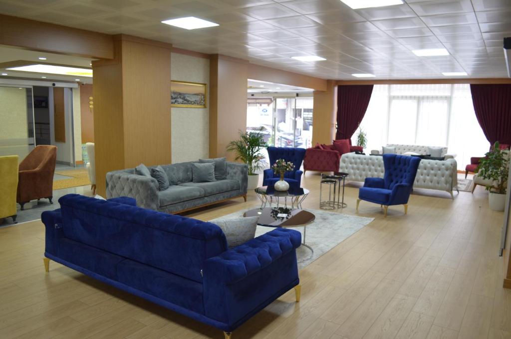 a living room with blue couches and chairs at Quars Garden Hotel in Koçyazı