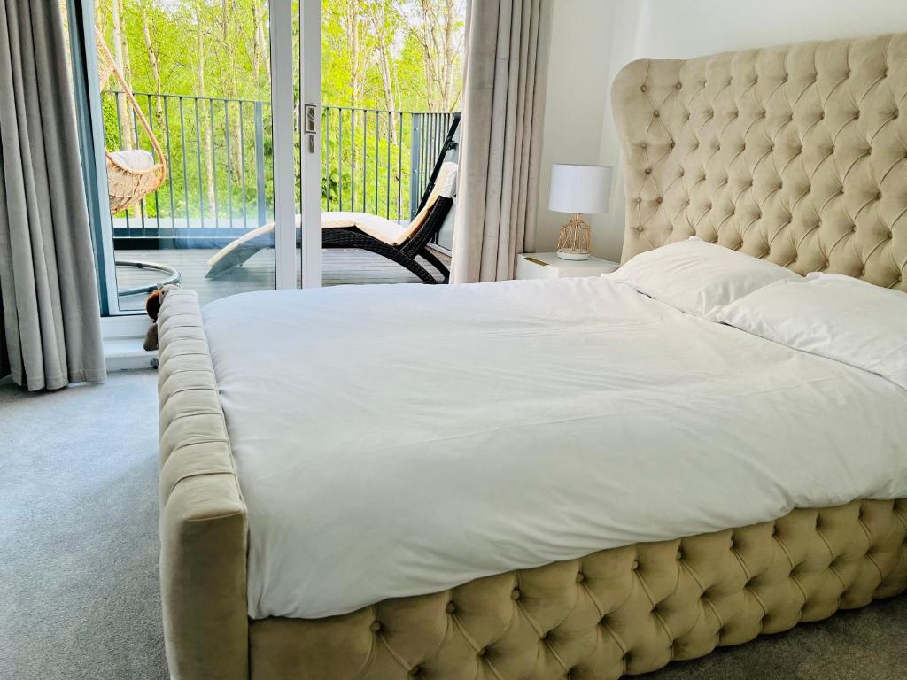 a bedroom with a large bed and a balcony at SEC HYDRO Executive Triplex Townhouse, Glasgow City Central, 3 Bedrooms/3 Bathrooms, 1 Living room/kitchen, 3 Floors, Master Bed's TERRACE, Main door, Garden, (Gym/Sauna/Steam/Indoor Swimming Pool Access), Parking - By CALA Homes in Glasgow