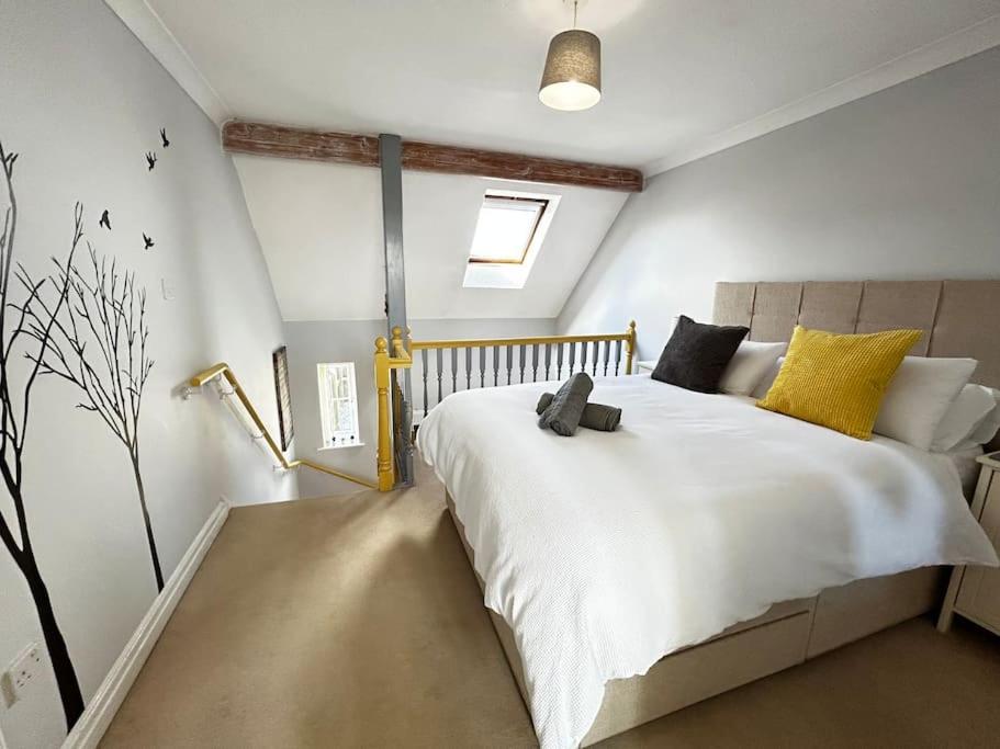 a bedroom with a large white bed with yellow pillows at Beautiful cottage in March/Cambridgeshire in March