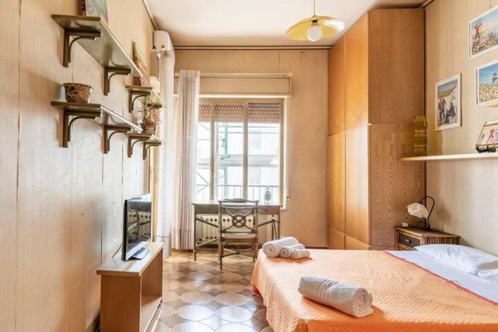 Schlafzimmer mit einem Bett, einem TV und einem Tisch in der Unterkunft Le stanze di Nonna Maria in Palermo