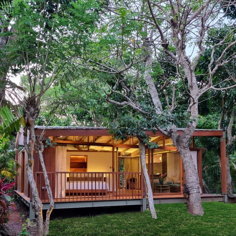 a house in the woods with a wrap around porch at Grün Resort Uluwatu in Uluwatu