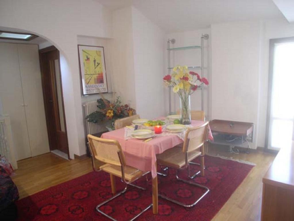 ein Esszimmer mit einem rosa Tisch und Stühlen in der Unterkunft Calle Burchio in Grado