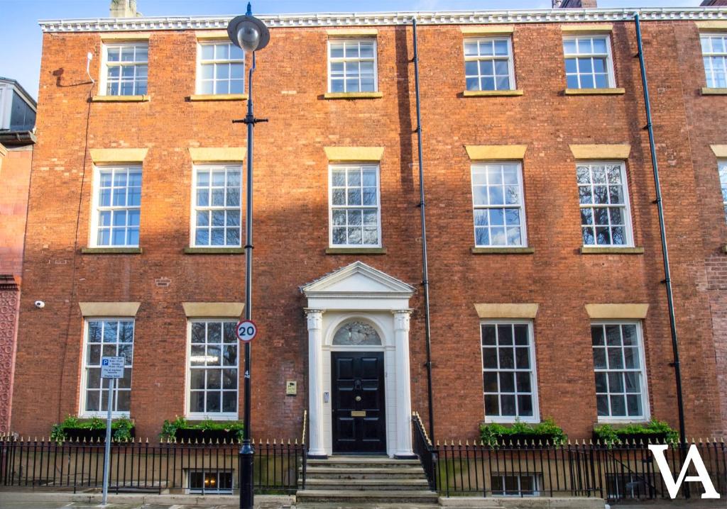 a red brick building with a black door at Velvet Apartments - 10 Park Square East in Leeds