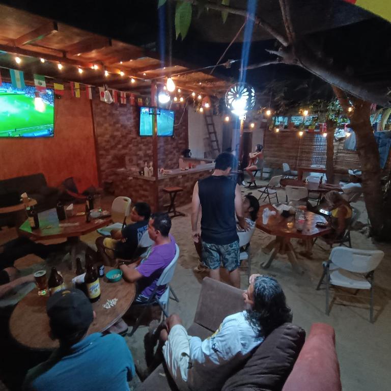 a group of people sitting at tables in a bar at HOTEL Y HOSTEl CAFE EL PESCADOR in Puerto Escondido