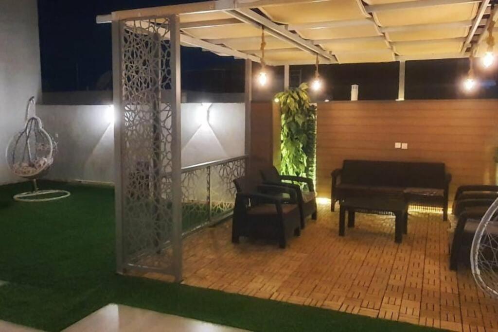 a room with a piano and a room with green grass at راحتك - إقامة وفخامة in Makkah
