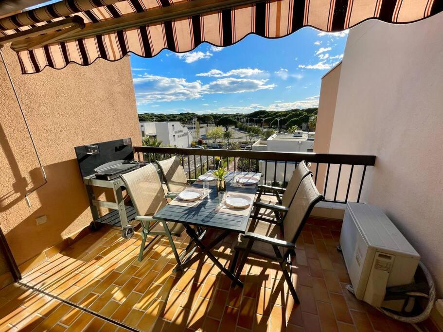 - un balcon avec une table et des chaises dans l'établissement Studio à 350m de la plage, terrasse ouverte, clim, au Grau-du-Roi