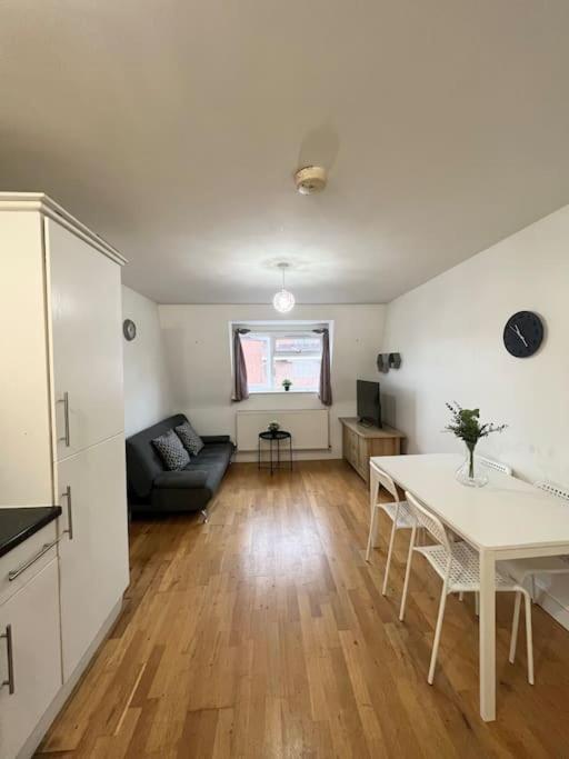 a living room with a table and a couch at New build 2 bed flat, London in London
