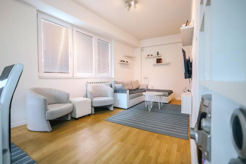 ein Wohnzimmer mit einem Sofa und einem Tisch in der Unterkunft Skopje Center City Apartments in Skopje