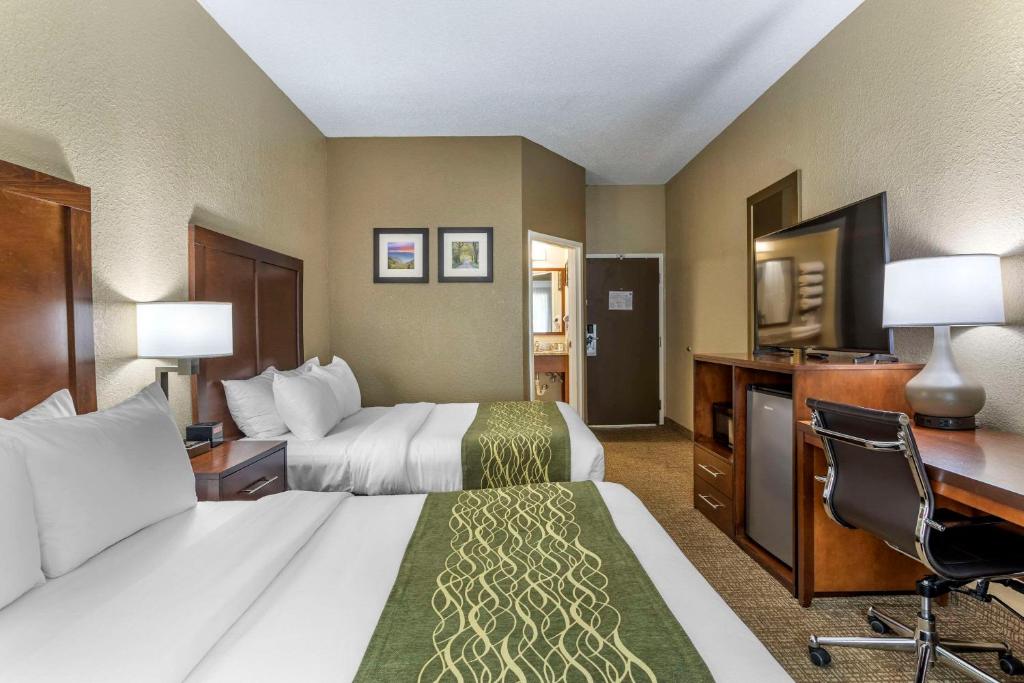 a hotel room with two beds and a desk at Comfort Inn South in Kingsport