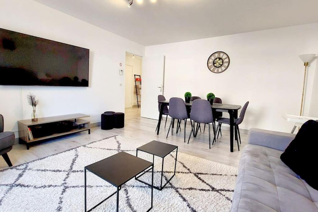 uma sala de estar com um sofá, uma mesa e cadeiras em Cosy Home 2, Cergy Le Haut, 6 personnes, 3 min gare, 30 min Paris, parking privé em Cergy