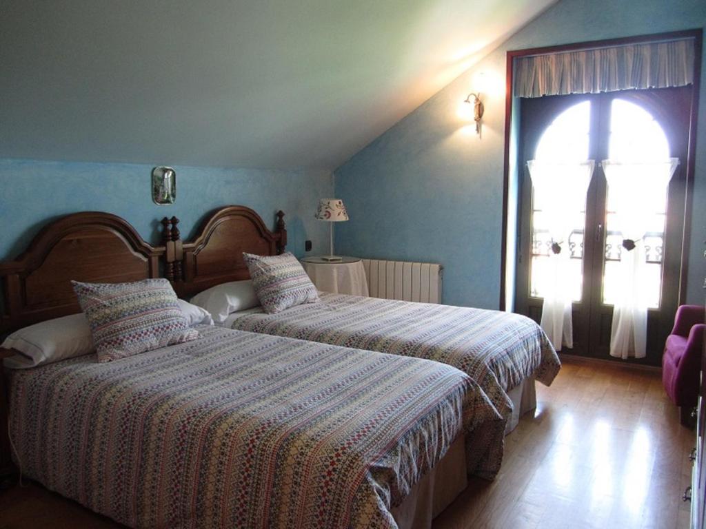 a bedroom with two beds and a window at Vivienda Sampedri in Santillana del Mar