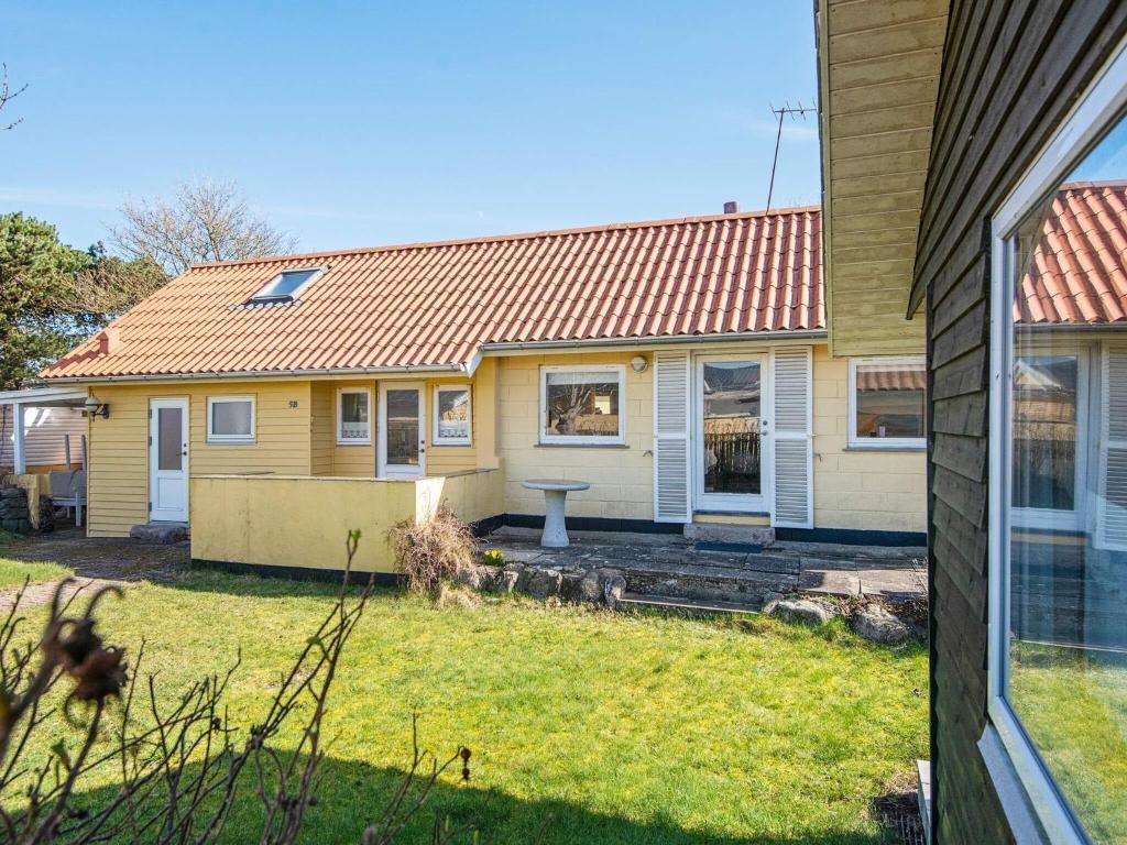 uma casa com um telhado laranja e um quintal em 5 person holiday home in Juelsminde em Juelsminde
