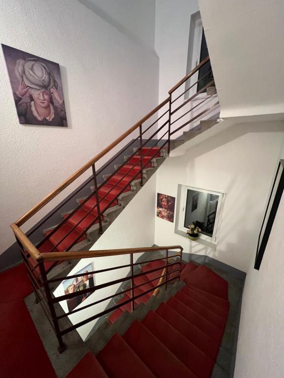 uma escada com alcatifa vermelha e uma escada vermelha em Cabbage Hostel em Belgrado