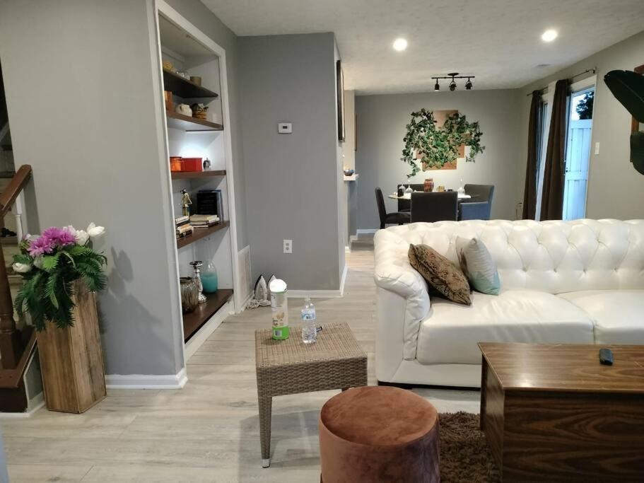 uma sala de estar com um sofá branco e uma mesa em Cozy Beautiful Luxury Townhouse em Frederick