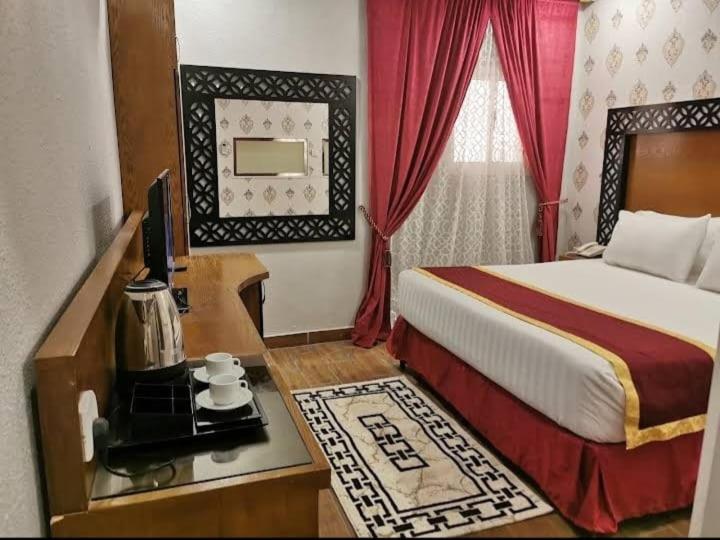 Farasanにあるفندق ساسو سويت للوحدات المفروشه والفندقيهのベッド、デスク、テレビが備わるホテルルームです。