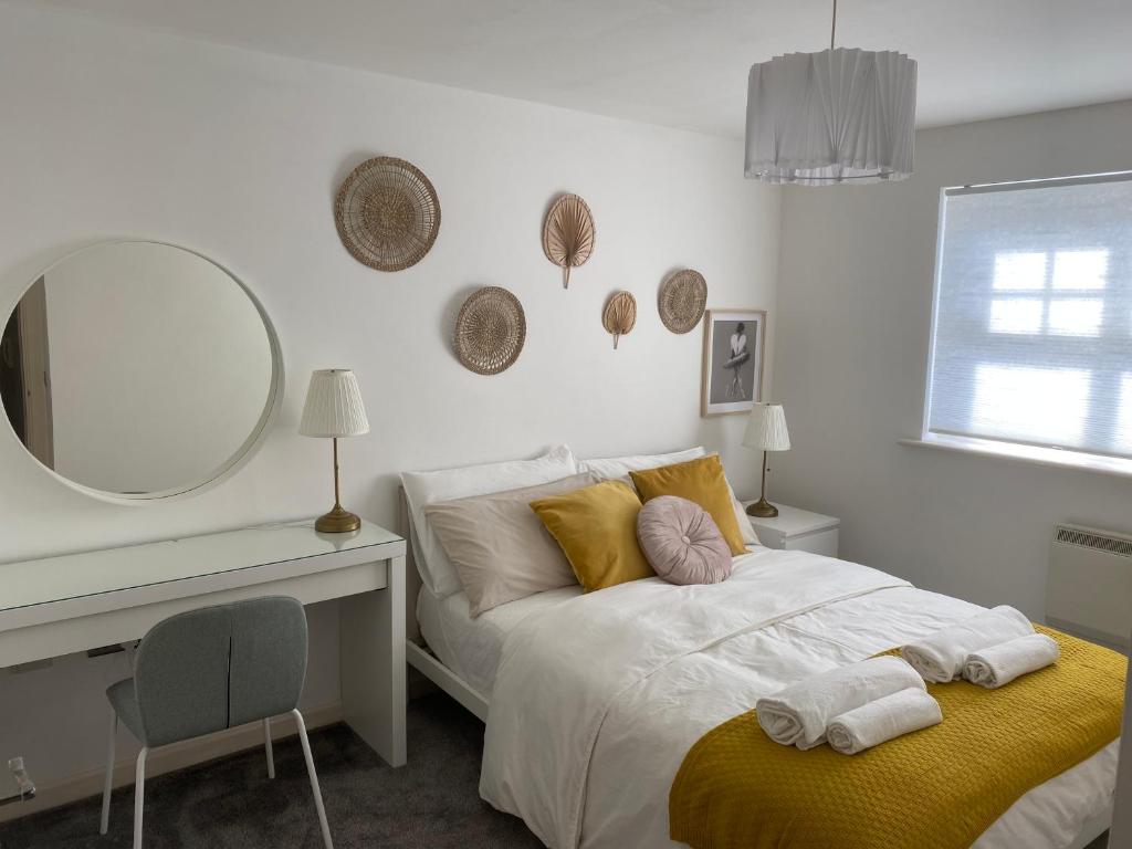 1 dormitorio con cama, escritorio y espejo en Marine Viewing 2 bedrooms flat en Mánchester