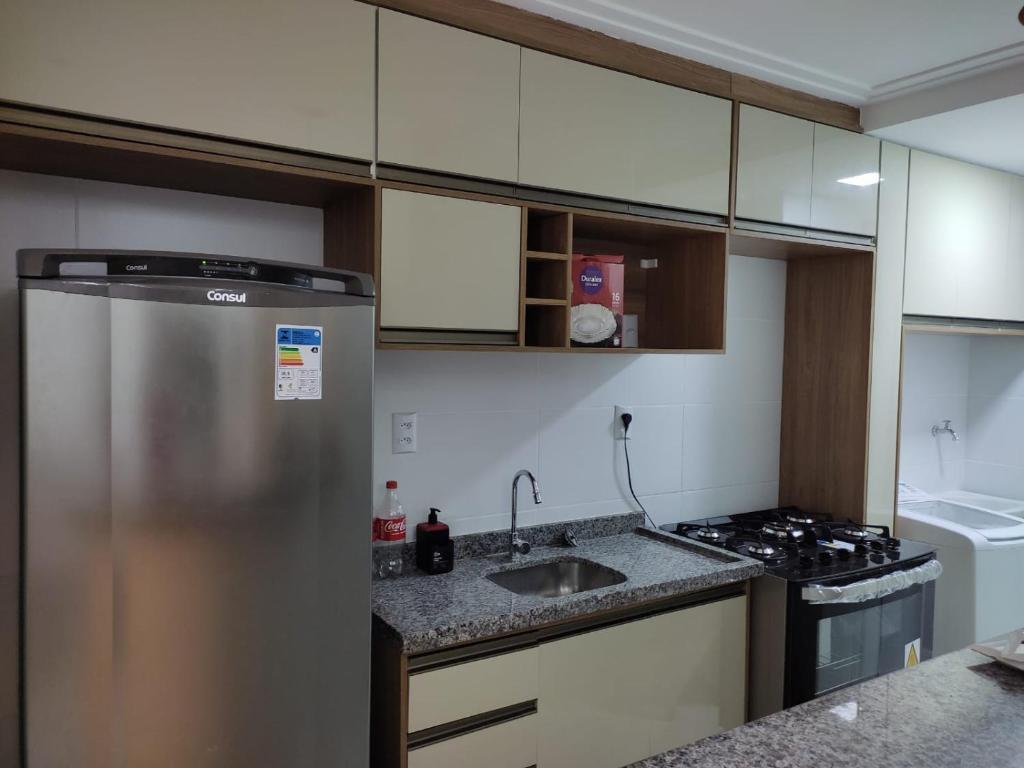 Una cocina con refrigerador de acero inoxidable y estufa. en Apartamento em Ondina, en Salvador