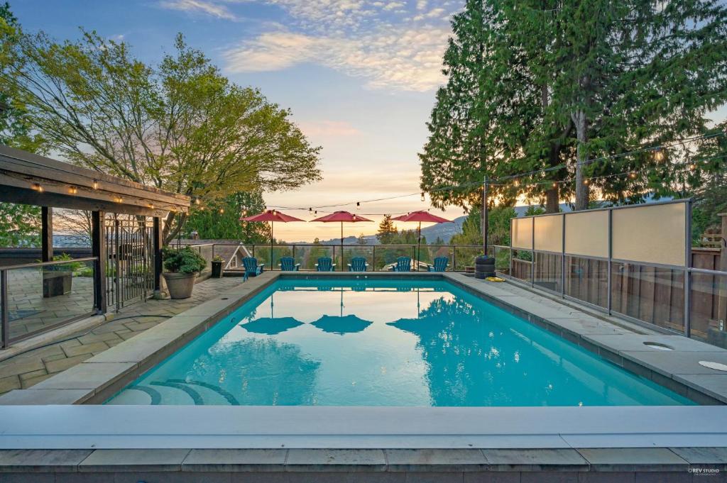 a swimming pool with blue water in a yard at Seymour Private Bedroom, Ensuite Bathroom with Shared Pool, Hot Tub with Views in North Vancouver