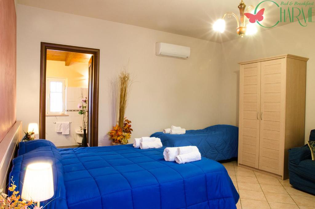 una camera con 2 letti blu di B&B Charme a Sora