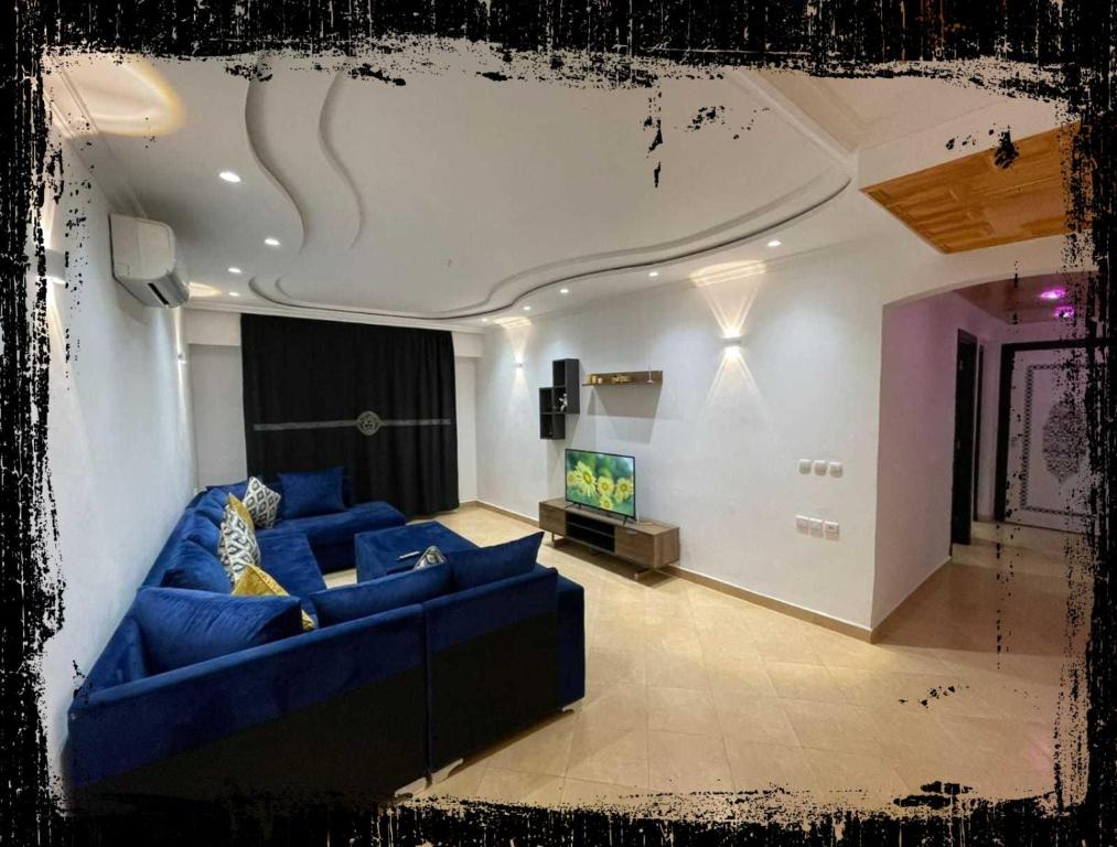 a living room with a blue couch and a tv at Standing Tétouan Apparts WIFI&PARKING in Tétouan