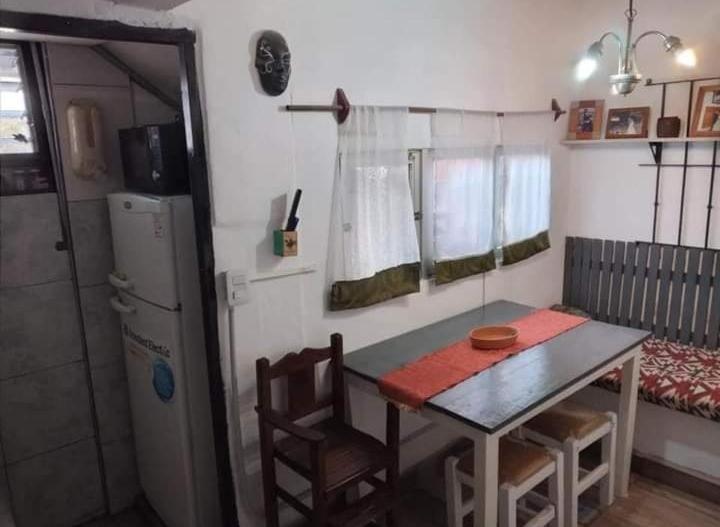 a small kitchen with a table and a refrigerator at Carlina I in Salta