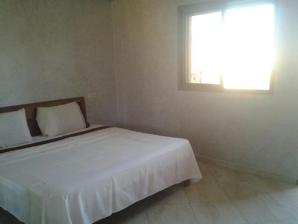 a bedroom with a white bed with a window at Khalid in Beni Mellal