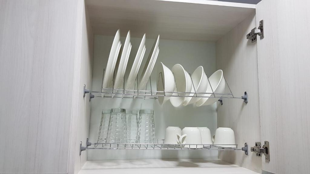 a shelf with white plates and vases on it at Coliving Cali in Cali