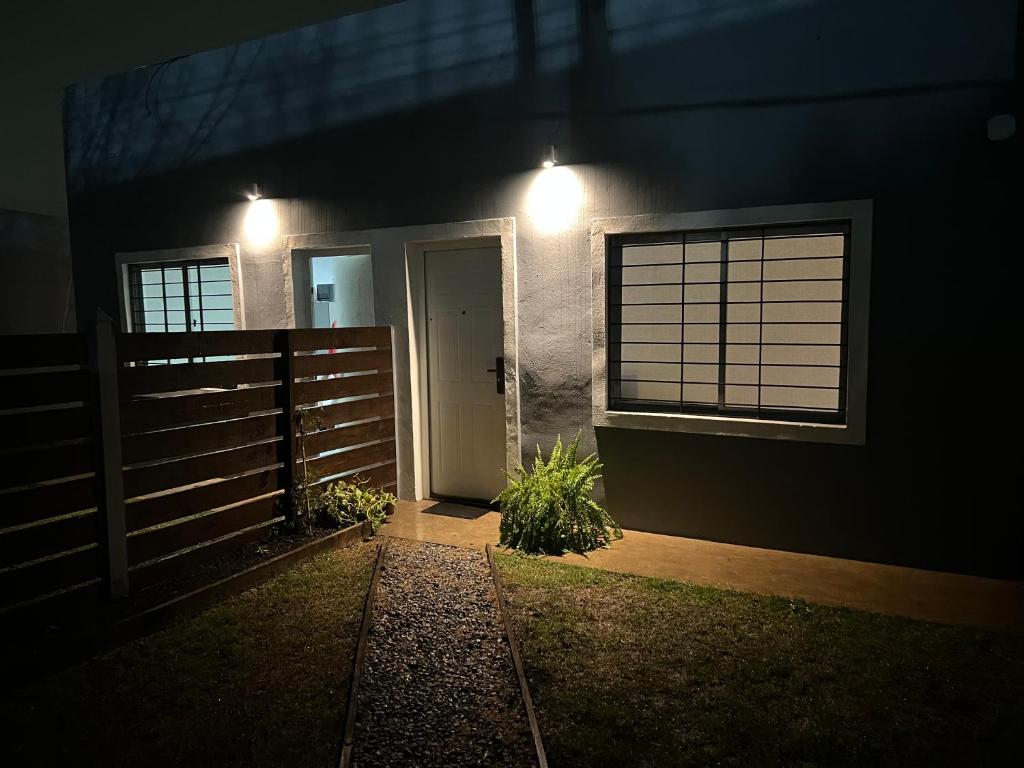 uma casa com uma cerca e uma porta à noite em Apart del Este 5 em Paysandú