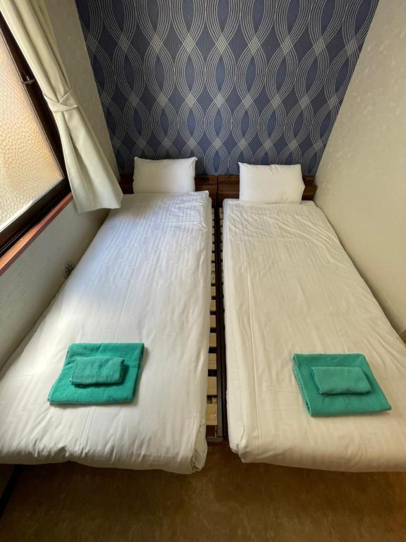 Postel nebo postele na pokoji v ubytování Kawasaki Station Inn