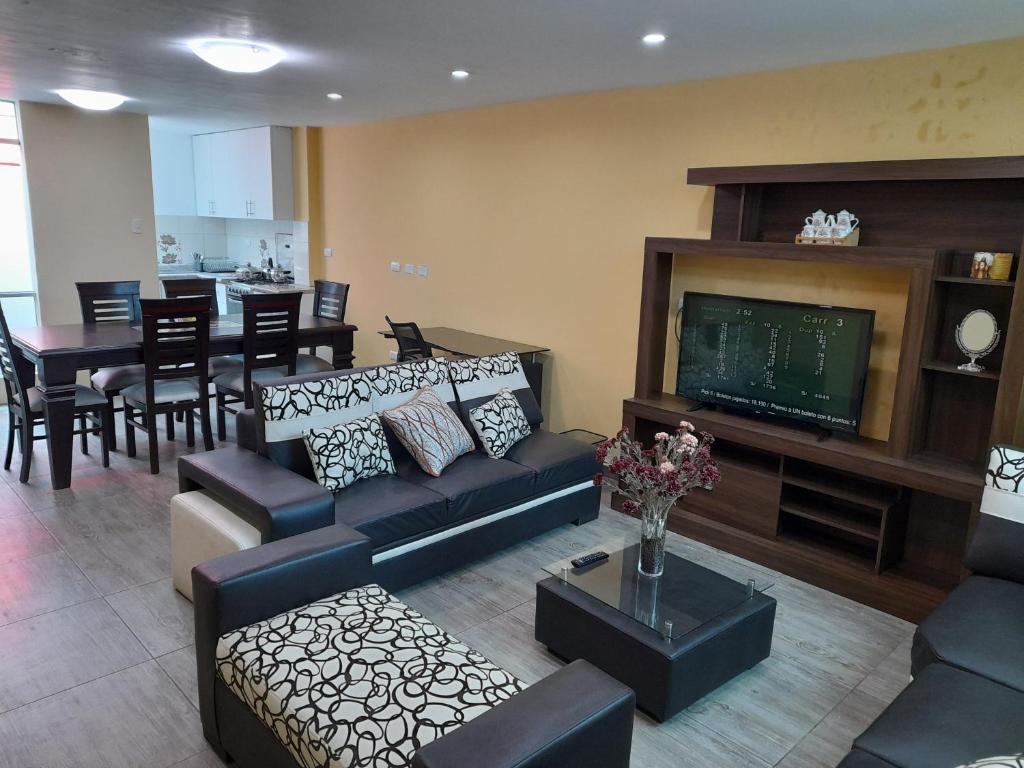 ein Wohnzimmer mit einem Sofa und einem Flachbild-TV in der Unterkunft Bonito departamento en Estreno - Cayma in Arequipa
