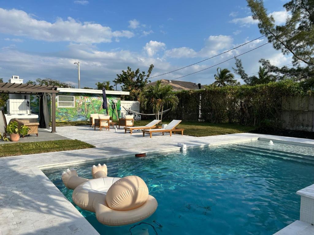 uma piscina com duas espreguiçadeiras e uma piscina em Jungle Cottage with luxury pool, hot tub and more! em Lake Worth