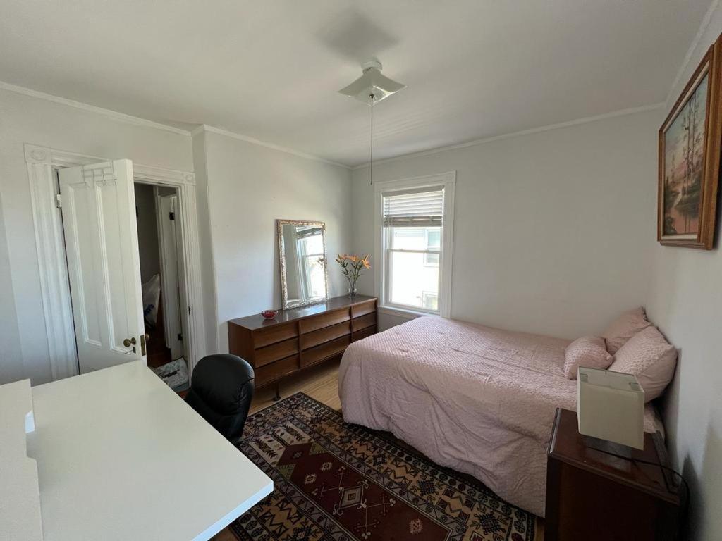 a bedroom with a bed and a desk and a mirror at Private Room in a Grand House in Boston