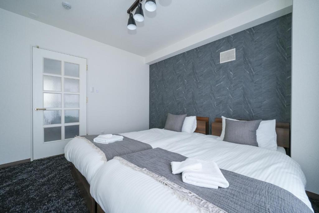 um quarto com uma grande cama branca com toalhas em 37MB HOTEL em Sapporo
