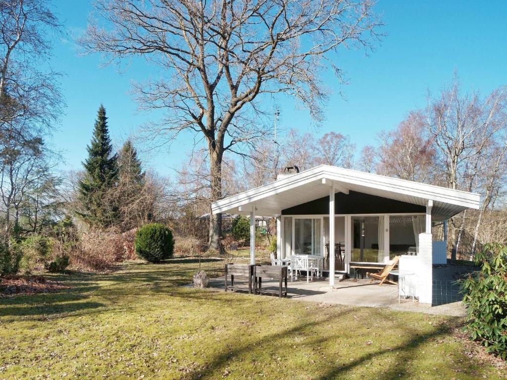un pabellón blanco con una mesa de picnic en un patio en Holiday home Melby IV, en Melby