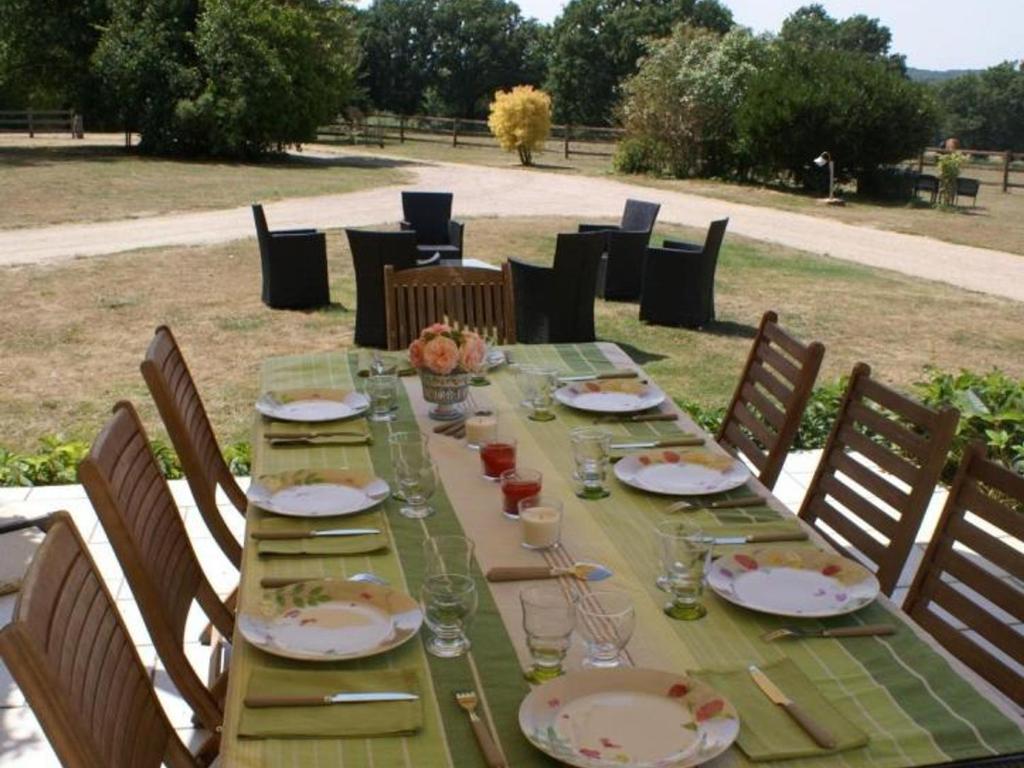 a long green table with plates and glasses on it at Gîte Le Brethon, 5 pièces, 8 personnes - FR-1-489-217 in Le Brethon
