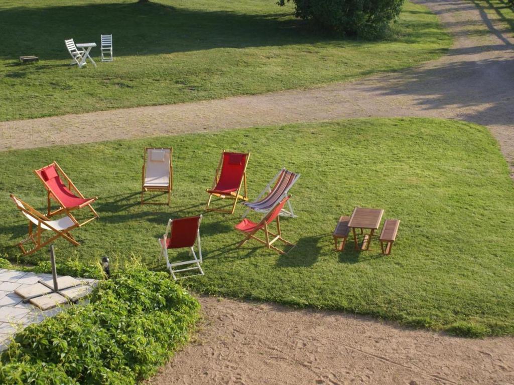 a group of chairs sitting in the grass at Gîte Le Brethon, 5 pièces, 8 personnes - FR-1-489-217 in Le Brethon